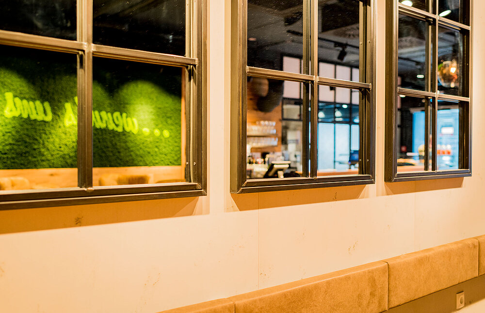 Markenbotschaft in apfelgrün integriert in Mooswand moosgrün, Evergreen Moos Premium, Freund, Café in Wien